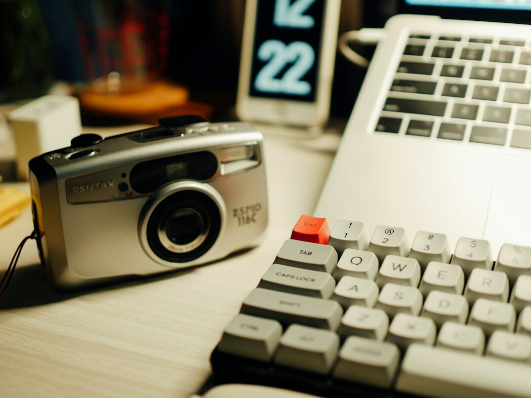 Bureau vu de dessus avec appareil photo, carnet et ordinateur portable